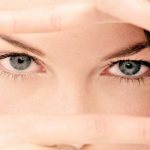 The girl looks through her fingers