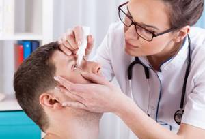 офтальмолог капает глаза пациенту